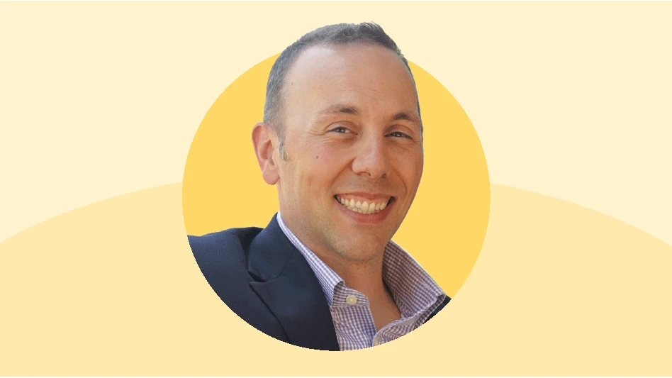 Headshot of a man in a navy suit with a yellow background.