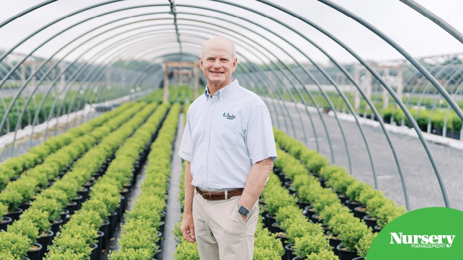 A man standing in a greenhouse.